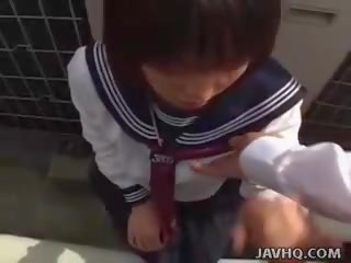 Japanisch teenager im ein schulmädchen draußen blasen spaß